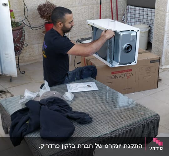 אדם מתקין מכשיר על קופסת קרטון של וולקנו